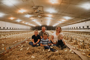 Tiffany Martinka and her family with broiler chicks in barn