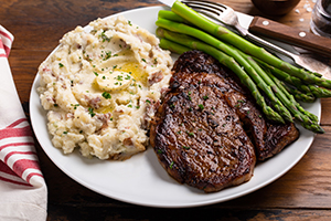 Steak and potatoes with asparagus on plate