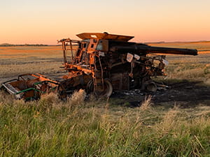 Burnt combine in field