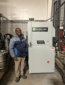 Mbaku Hamidu Adma standing next to his Carbon Capture Machine