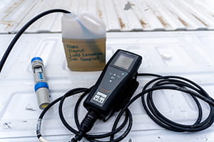 Water testing equipment including probe and jog of dugout water on truck bed