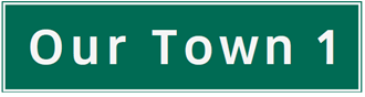 A green road sign announcing our Town in 1km.