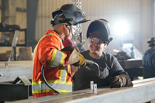 Apprentice Welder Kalene working in a welding shop with journeyperson Welder Adam.