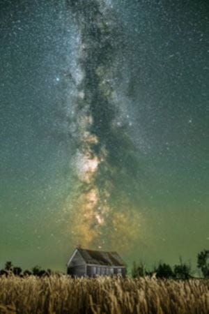 Cabin with a Green and blue sky with multiple stars