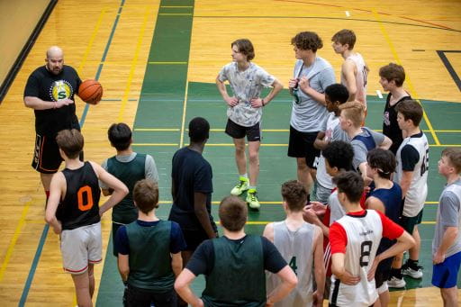 Basketball coach working with players on the court. 