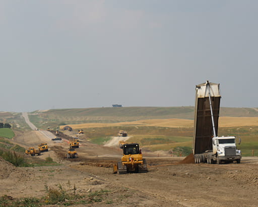 Heavy equipment moving dirt during highway construction