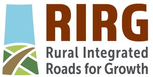 Text: RIRG Rural Integrated Roads for Growth. Illustration on the left in the rectangle shape of the Saskatchewan province. Top of the rectangle is light blue, the bottom of the rectangle is different shades of green and a brown longer rectangle to mimic a road going through Saskatchewan.  